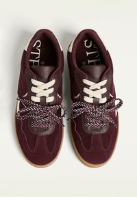 Bordowe sneakersy wykonane z zamszu i skóry z teksturowanymi akcentami, wyposażone w beżowe sznurowadła oraz wzorzyste, wielokolorowe sznurowadła. Podeszwa z gumowej gumy.