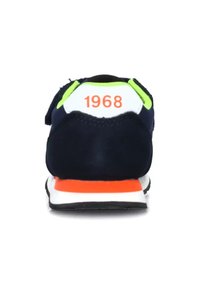 Scarpa da ginnastica blu navy con accenti verde neon e tallone bianco. Presenta "1968" in arancione sul retro. Suola intermedia spessa bianca con striscia arancione. Forma arrotondata.
