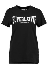 Černé bavlněné tričko s velkým bílým textem, který zní "SUPERLATIV" nad "KOMPLOT," s kulatým výstřihem a krátkým rukávem.