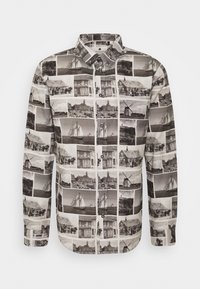 Chemise à boutons ornée d'un imprimé de collage photo en noir et blanc représentant des scènes historiques, avec un col classique, des manches longues et une patte de boutonnage.