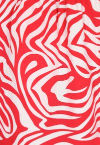 Rood en wit stof met een draaiend, abstract zebrapatroon. Gladde textuur met een zachte afwerking en variërende lijndiktes in het ontwerp.