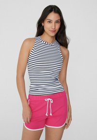 Top sin mangas a rayas en azul marino y blanco, combinado con pantalones cortos rosas con ribete blanco y cordón. Tejido suave y elástico.
