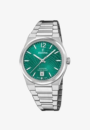 Nerūsējošā tērauda pulkstenis ar zaļu rakstainu ciparnīcu, sudraba stundu rādītājiem un datuma logu pie 6. Safīra stikls un ūdensnecaurlaidīgs dizains.