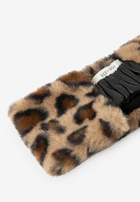 Accessoire en fausse fourrure imprimé léopard avec un panneau de tissu noir froncé et une étiquette de marque. Texture douce et détail motif animalier.