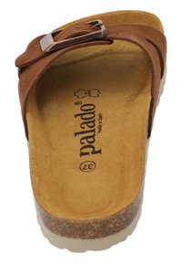 Bruine suede slide sandaal met een kurken voetbed, met een metalen gesp als accent. Zachte textuur, gevormde vorm voor comfort en gemodelleerd ontwerp.
