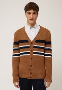 Brun stickad cardigan med V-hals, med horisontella marinblå, vita och bruna ränder, samt sex bruna knappar fram.