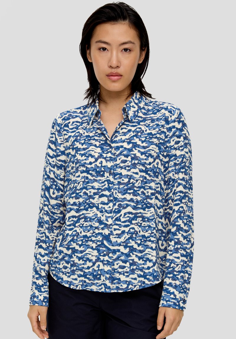 Kariertes Hemd mit einem blauen und weißen abstrakten Muster, langen Ärmeln, Kragen und abgerundetem Saum. Hergestellt aus einem weichen, leichten Stoff.