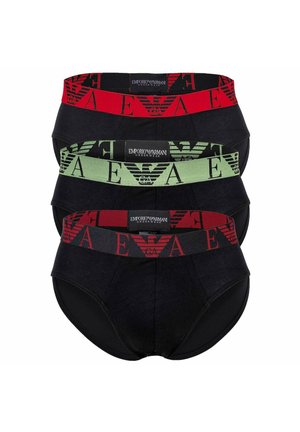 Trois paires de slips noirs Emporio Armani empilées, chacune avec une ceinture de marque de couleur différente en rouge, vert et noir avec du rouge.