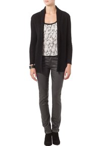 Černý žebrovaný cardigan s otevřeným předním dílem, vrstvený přes vzorovaný top v bílé a šedé. Spárováno se slim-fit šedými kalhotami a kotníkovými botami.