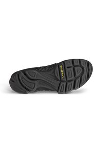 Semelle de chaussure de sport noire en caoutchouc texturé, avec des rainures flexibles et un logo jaune proéminent. Conception légère pour un mouvement naturel.