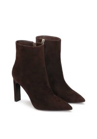 Brūni zamšīgi potīšu zābaki ar norādītu purngalu un stilu augsto papēdi. Iezīmēta ar sānu rāvējslēdzēju un gludu iekšējo oderi.