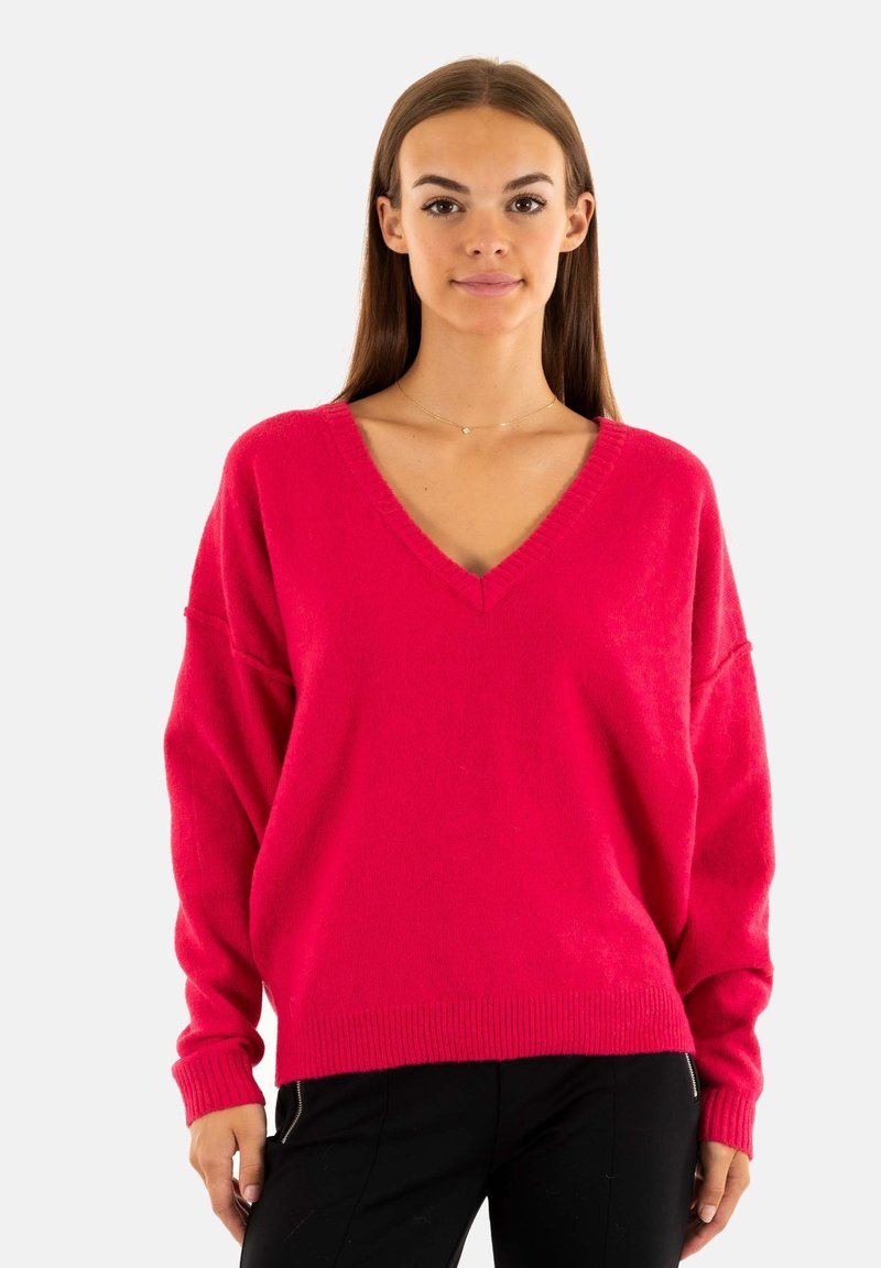 Fuchsia oversized trui met een V-hals, geribbelde zoom en lange mouwen. Zachte textuur en comfortabele pasvorm, gestyled met donkere broeken.
