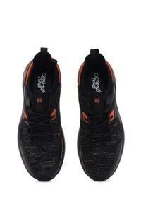 Chaussures de sport noires avec un dessus en tissu texturé, des accents orange et des lacets. Elles possèdent une semelle intérieure rembourrée et une semelle en caoutchouc pour l'adhérence.