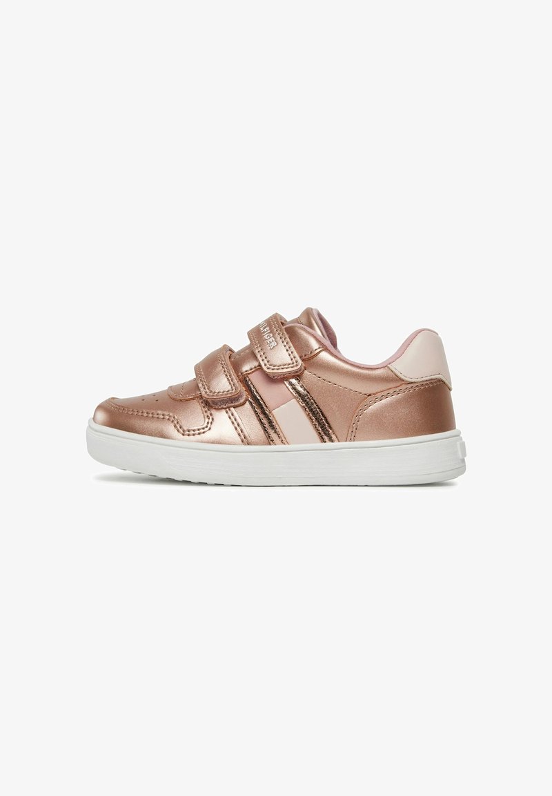 Baskets rose doré métalliques avec deux sangles Velcro, semelle en caoutchouc blanc et accents de panneaux contrastés. Texture lisse avec des détails perforés.
