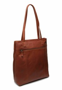 Sac en cuir marron avec deux poignées, doté d'une poche zippée horizontale à l'avant, se tenant debout sur un fond blanc.