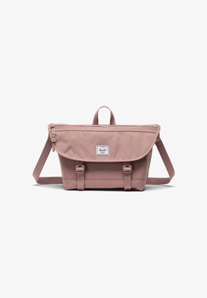 Sac messenger rose pâle avec un tissu texturé, fermeture à rabat, sangle ajustable et deux boucles à l'avant. Doté d'une poignée supérieure et d'une étiquette de marque.