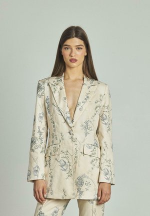 Blazer in lino beige con dettagli di ricamo floreale blu, scollatura a V profonda, rever, e due tasche frontali.
