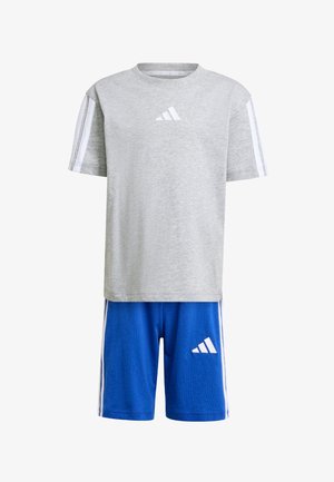 Camicetta grigia a maniche corte con logo bianco Adidas e strisce bianche sulle maniche, abbinata a pantaloni corti blu con logo e strisce bianche Adidas.
