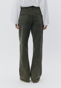 Olivengrønne jeans med brede ben, lavet af denim, med høj talje, design med fem lommer og subtilt falmet struktur.