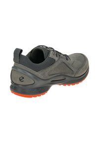 Grijze sneaker met een gestructureerde suède bovenkant en accenten van mesh. Voorzien van een gevoerde zool in zwart met een oranje loopvlak voor grip.