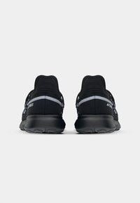 Black athletic shoes with a smooth texture, featuring grey accents and a thick rubber sole. The design includes a structured heel and lacing system.