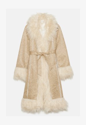 Beige jas met een fluffy witte nepbont kraag en manchetten. Heeft een ceintuur en een textiel met een subtiel patroon.