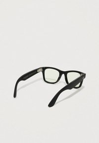 Lunettes rectangulaires noires avec des verres transparents, présentant une finition brillante, des accents en métal et un logo de marque subtil sur la branche.