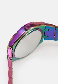 Orologio dai colori arcobaleno con una finitura metallica e lucida. Presenta un quadrante rotondo, una corona testurizzata e un design a braccialetto collegato. Parte posteriore argento.