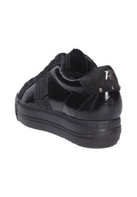 Baskets noires brillantes avec languette de talon en daim ornée d'un "R" métallique et de petites clous, semelle épaisse avec "R3" embossé à l'arrière.