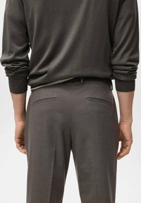 Pantaloni grigi su misura con una texture liscia, tasche laterali e passanti per la cintura. La vista mostra la parte posteriore, evidenziando il design minimalista.