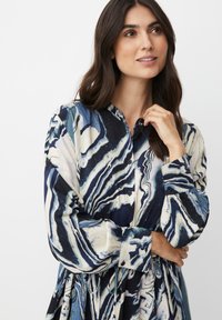 Knopfkleid mit einem marmorierten Muster in Marineblau, Weiß und Teal. Mit Kragen, langen Ärmeln und elastischem Taillendetail.