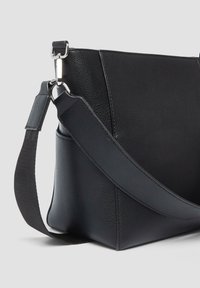 Borsa a spalla nera in pelle con finitura testurizzata, dotata di una tracolla ampia e accessori in metallo argentato, design angolato e dettagli di cucitura sottili.