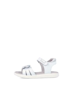 Sandal de cuero blanco con un lazo plateado, correa ajustable y diseño de puntera abierta. Presenta una suela texturizada para mayor agarre.