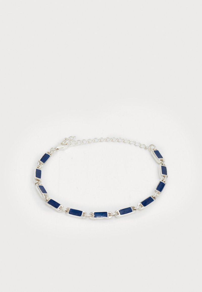 Hõbedane käevõru, millel on neljakandilised tumedat sinist kivi, mis on ühendatud väikeste hõbedaste silmadega ja reguleeritava aheliku klambriga valge tausta peal.