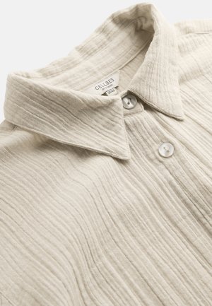 Beige textuur overhemd met kraag, voorzien van twee witte knopen en een zichtbaar kledinglabel aan de binnenkant van de halslijn met merk en maat.
