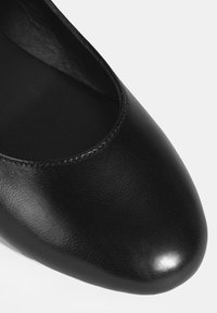 Schwarze Leder-Ballettschuhe mit rundem Zeh, glatter Textur und einem subtilen Glanz. Verfügt über ein tief ausgeschnittenes Design und minimale Nähdetails.