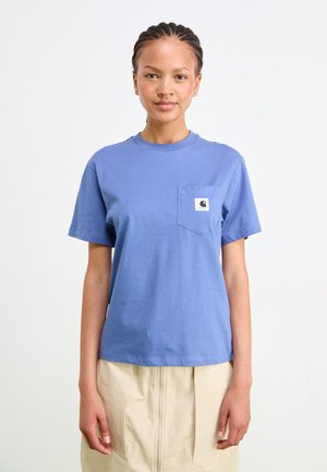 Blå bomull T-skjorte med rund hals, korte ermer og en lomme på venstre bryst med et logo-patch. Stoffet ser glatt og lett ut.