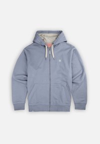 Sweat à capuche zippé bleu clair avec une capuche doublée beige, des poches avant et un petit logo sur la poitrine. Fabriqué en tissu doux et texturé.