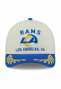 Beige Kappe mit blauer Krempe. "RAMS" und "LOS ANGELES, CA" in Blau gestickt. Krempe verfügt über gelbe dekorative Nähte.