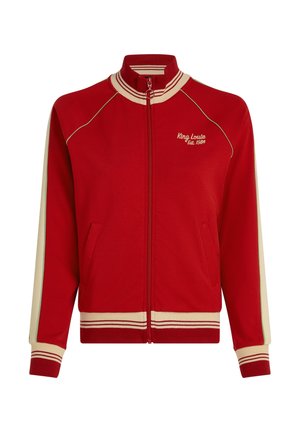 Czerwona kurtka na zamek z kremowymi akcentami, prążkowanym kołnierzem, długimi rękawami i bocznymi kieszeniami. Na przodzie haft "King Louie Est. 1989".