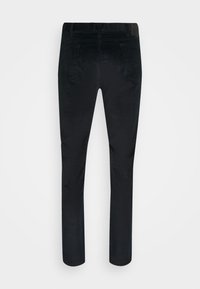 Pantalon en velours côtelé noir slim fit avec poches arrière, passants de ceinture et coupe droite, vu de dos.