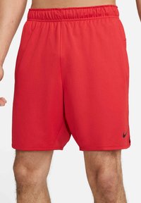 Czerwone spodenki sportowe wykonane z lekkiego materiału, z elastycznym pasem. Posiadają boczne kieszenie oraz małe czarne logo na dolnym brzegu.