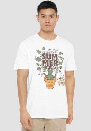 Young man wearing white T-shirt with potted Mandrake plant graphic and text "Don't cry, it's the summer holidays" and herbal ear muffs.