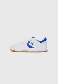 Baskets de sport blanches avec des accents bleus, arborant un logo en forme d'étoile, cuir texturé et semelle en caoutchouc naturel. Système de laçage.