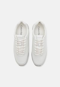 Hvite lær sneakers med rund tå, snøring, polstret krage og teksturert gummisåle. Prentet logo på tungen.