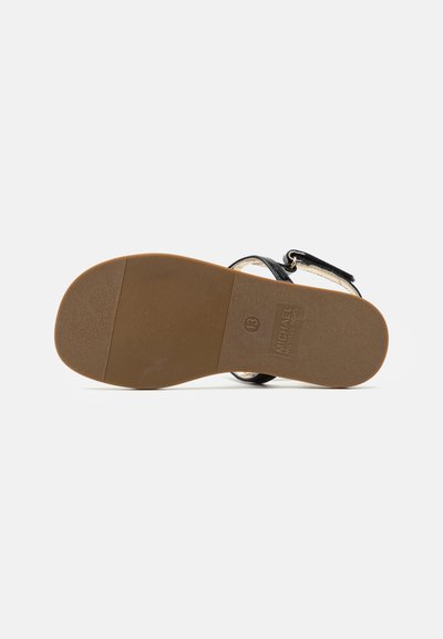 Svart sandal med en slät läderöverdel, justerbar vristrem och en brun gummisula med ett strukturerat greppmönster.