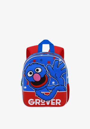 Sac à dos bleu et rouge avec un personnage de dessin animé, un dos texturé, des motifs d'étoiles, et une fermeture éclair à l'avant. Comprend une poignée supérieure.