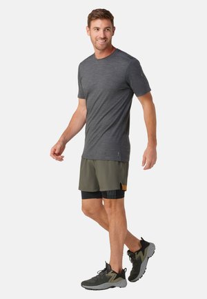 Donkergrijze t-shirt met korte mouwen, lichte olijfgroene shorts en zwarte sportschoenen met grijze accenten. Eenvoudig ontwerp, casual pasvorm.