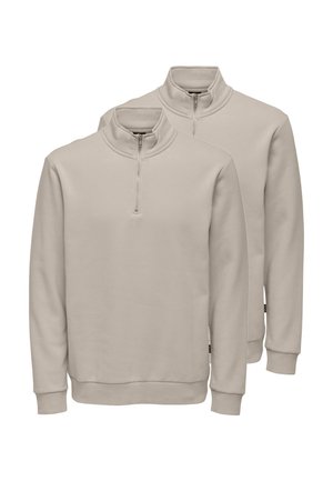 Twee beige fleece pullovers met een kwart-ritssluiting, geribbelde manchetten en zomen, afgebeeld op een effen witte achtergrond.