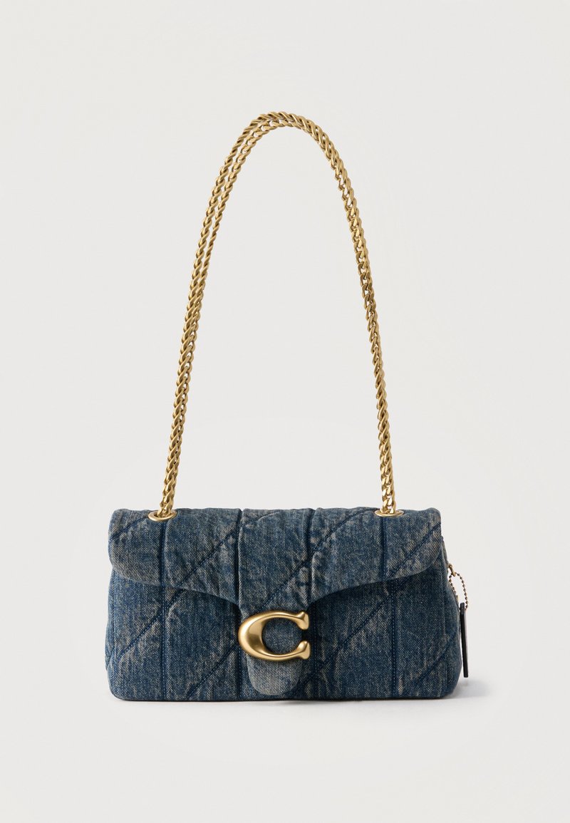 Ραμμένη τσάντα ώμου από τζιν με χρυσή αλυσίδα και μεγάλο χρυσό κούμπωμα "C" στο μπροστινό καπάκι, τοποθετημένη σε απλό λευκό φόντο.